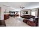 Open living space featuring tile floors, modern fireplace, and a seamless transition to the dining and kitchen areas at 14258 W Lisbon Ln, Surprise, AZ 85379