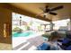 Covered patio with ceiling fan, outdoor kitchen, and a view of the sparkling pool at 14258 W Lisbon Ln, Surprise, AZ 85379