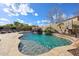 Backyard pool area with a waterfall feature, basketball hoop, and desert landscaping at 14258 W Lisbon Ln, Surprise, AZ 85379