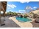 Large backyard with a luxurious pool, waterfall, basketball court, and covered patio at 14258 W Lisbon Ln, Surprise, AZ 85379