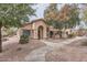 Charming single-story home featuring a stucco facade, arched entryway, and well-maintained landscaping at 14300 W Bell Rd # 307, Surprise, AZ 85374