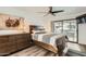 Comfortable main bedroom with wood floors, neutral decor, ceiling fan, and sliding glass door at 14300 W Bell Rd # 307, Surprise, AZ 85374