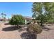 Serene backyard featuring desert landscaping, mature trees, and a patio with seating, perfect for outdoor living at 15561 W Vista Grande Ln, Surprise, AZ 85374