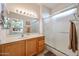 Bright bathroom featuring a walk-in shower, oak vanity, and a view into the main bedroom at 15561 W Vista Grande Ln, Surprise, AZ 85374