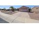 Single story home with low maintenance rock landscaping, mature palm trees, and a two car garage at 15561 W Vista Grande Ln, Surprise, AZ 85374