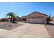 Single story home with low maintenance desert landscaping, mature palm trees, and a two car garage at 15561 W Vista Grande Ln, Surprise, AZ 85374