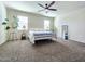 Inviting bedroom with two bright windows, a ceiling fan, neutral walls and carpet at 18809 W Wilson St, Buckeye, AZ 85326