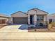 Beautiful single Gathering home showcasing desert landscaping, a spacious driveway, and covered porch at 18809 W Wilson St, Buckeye, AZ 85326