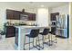 Modern kitchen with stainless steel appliances, dark wood cabinets, and a granite countertop island with seating at 18809 W Wilson St, Buckeye, AZ 85326