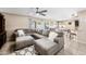 Bright, open-concept layout with a gray sectional sofa and seamless flow to dining and kitchen at 1928 E 39Th Ave, Apache Junction, AZ 85119