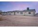 View of the home's backyard, highlighting the expansive lot, fencing, and solar panels on the roof at 19348 W Brave Rd, Buckeye, AZ 85326