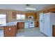 View of a functional kitchen with white appliances, wood cabinetry and tile flooring at 19348 W Brave Rd, Buckeye, AZ 85326