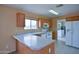 Functional kitchen featuring white appliances, wood cabinetry, and a breakfast bar at 19348 W Brave Rd, Buckeye, AZ 85326