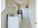 A functional laundry room featuring tile floor, cabinets and washer/dryer at 19348 W Brave Rd, Buckeye, AZ 85326