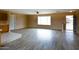 Bright and open living room featuring wood-look floors, a ceiling fan and large window at 19348 W Brave Rd, Buckeye, AZ 85326