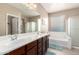 Well lit bathroom features double sinks, a tub, and a separate shower at 20905 N Danielle Ave, Maricopa, AZ 85138