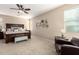 A spacious bedroom features a ceiling fan, carpeted floors, and stylish decor at 20905 N Danielle Ave, Maricopa, AZ 85138