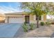Charming single-story home featuring a well-maintained front yard, desert landscaping, and an attached two-car garage at 20905 N Danielle Ave, Maricopa, AZ 85138