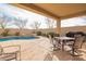 Covered outdoor dining and living space with a nearby pool and spa at 20905 N Danielle Ave, Maricopa, AZ 85138