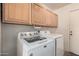 Laundry room features modern washer and dryer and ample cabinet space above at 2327 W Rockwell Ct, Chandler, AZ 85224