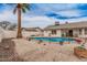 Backyard pool with rock landscape, palm tree, and covered patio at 2327 W Rockwell Ct, Chandler, AZ 85224