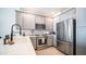 Well-lit kitchen featuring stainless steel appliances, quartz countertops, and gray cabinets at 2511 W Queen Creek Rd # 479, Chandler, AZ 85248