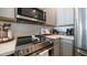 A close-up of the stainless steel oven and microwave showcases modern appliances and sleek gray cabinetry at 2511 W Queen Creek Rd # 479, Chandler, AZ 85248