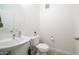 A clean and minimalist powder room features a pedestal sink and a round mirror at 2511 W Queen Creek Rd # 479, Chandler, AZ 85248