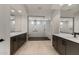 Sleek bathroom with a frameless glass shower, double vanities, and modern fixtures, exuding elegance at 26535 W Mcrae Dr, Buckeye, AZ 85396