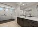 Stylish bathroom showcasing a frameless shower with black fixtures, a vanity, and tiled flooring at 26535 W Mcrae Dr, Buckeye, AZ 85396