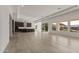 Open-concept living space featuring tile flooring, large windows, and a modern kitchen with dark cabinetry at 26535 W Mcrae Dr, Buckeye, AZ 85396