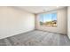 Carpeted bedroom with a large window offering natural light and views of the neighborhood at 26982 W Lone Cactus Dr, Buckeye, AZ 85396