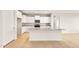 Modern kitchen with a granite-topped island, stainless steel appliances, and white cabinetry at 26982 W Lone Cactus Dr, Buckeye, AZ 85396