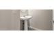 Elegant powder room with a pedestal sink and stylish mirror at 26982 W Lone Cactus Dr, Buckeye, AZ 85396