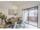 Cozy dining area with a round wood table set for four, a modern light fixture, and access to a balcony at 3102 E Clarendon Ave # 210, Phoenix, AZ 85016