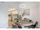 Dining area with a round wood table set for four, a kitchen with white cabinets, and abundant natural light at 3102 E Clarendon Ave # 210, Phoenix, AZ 85016