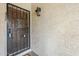 Close-up showcasing a wood front door with a black security gate and a vintage-style outdoor light fixture at 3102 E Clarendon Ave # 210, Phoenix, AZ 85016