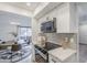 Open kitchen area featuring updated oven and microwave, quartz countertops, and adjoining dining room at 3102 E Clarendon Ave # 210, Phoenix, AZ 85016
