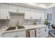 Updated kitchen featuring white cabinetry, quartz countertops, stainless steel sink, and stainless steel dishwasher at 3102 E Clarendon Ave # 210, Phoenix, AZ 85016