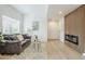 Modern living room with a wood panel fireplace, a gray sofa with decor, and abundant natural light, creating an open space at 3102 E Clarendon Ave # 210, Phoenix, AZ 85016