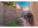 Small backyard featuring a red-brick paver patio, BBQ, block-wall fencing, and minimal landscaping at 335 S Travis --, Mesa, AZ 85208