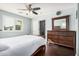 Sunlit bedroom featuring wood flooring, dresser, and a cozy white comforter, creating a warm and inviting space at 335 S Travis --, Mesa, AZ 85208
