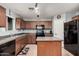 Well-designed kitchen with tile floors, functional island, and dark appliances against brown cabinetry at 335 S Travis --, Mesa, AZ 85208