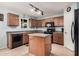 Efficient kitchen space featuring tile flooring, dark brown cabinets, black appliances, and a central island at 335 S Travis --, Mesa, AZ 85208