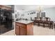 Open-concept living room with kitchen island, dining area, and comfortable gray couches under a ceiling fan for a modern appeal at 335 S Travis --, Mesa, AZ 85208