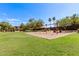 Community swing set in a grassy area with a sand base, perfect for outdoor fun at 335 S Travis --, Mesa, AZ 85208