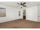 Spacious bedroom with a ceiling fan and windows providing natural light and open bathroom doorway at 346 E Red Mesa Trl, San Tan Valley, AZ 85143