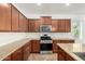 Well-lit kitchen featuring granite countertops, stainless steel appliances, and warm wood cabinetry at 346 E Red Mesa Trl, San Tan Valley, AZ 85143