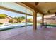 Covered patio with ceiling fans overlooking a backyard oasis featuring a pool, mature landscaping, and artificial turf at 346 E Red Mesa Trl, San Tan Valley, AZ 85143