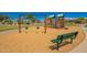 A view of a well-maintained community park with a playground, swings, bench, and sidewalks at 346 E Red Mesa Trl, San Tan Valley, AZ 85143